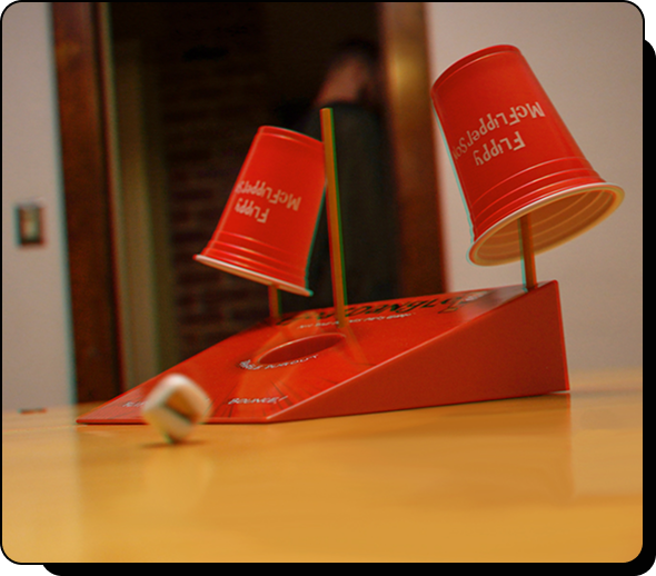 Red cups on tilted board, dice rolling.